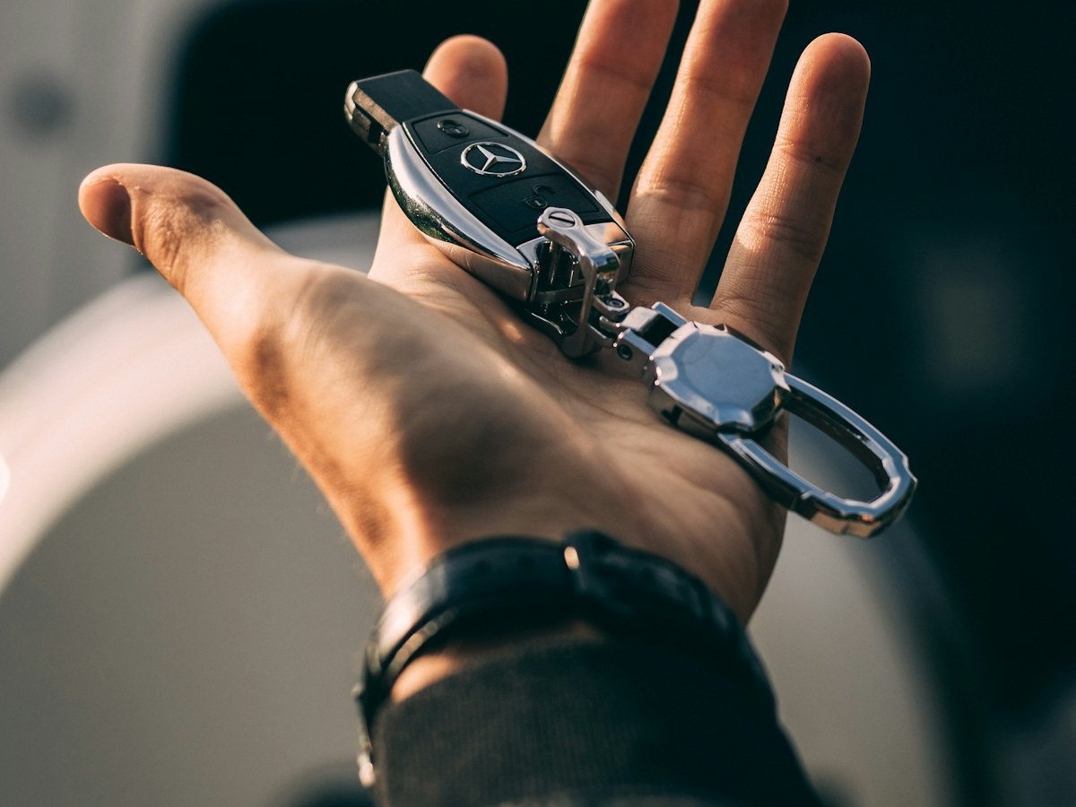Hand holding a Mercedes-Benz key fob